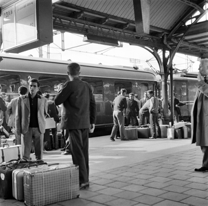 849068 Afbeelding van de aankomst van een groep Italiaanse mannen (gastarbeiders?) met een D-trein op het perron van ...